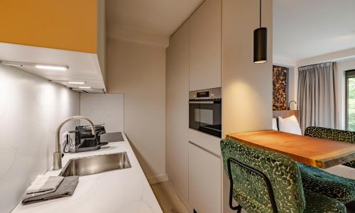 a kitchen with a sink and a table with chairs at Htel Serviced Apartments Amstelveen in Amstelveen