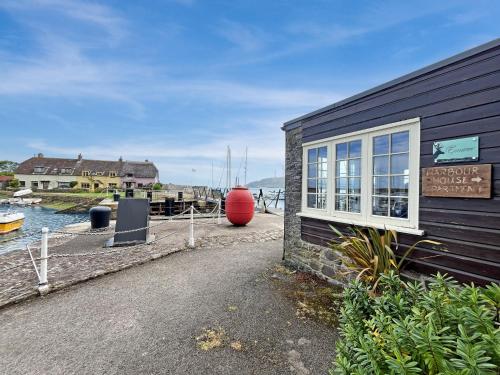 a building with a sign next to a body of water at Harbour House Studio, Porlock Weir in Culbone