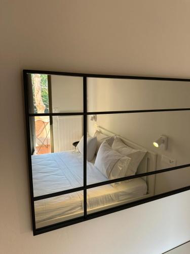 a mirror reflecting a bed with white pillows at Blue Cozy Nest in Rhodes Town