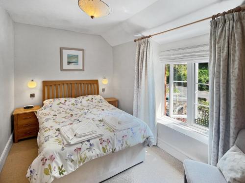 a bedroom with a bed and a window at Magnolia Cottage in Porlock