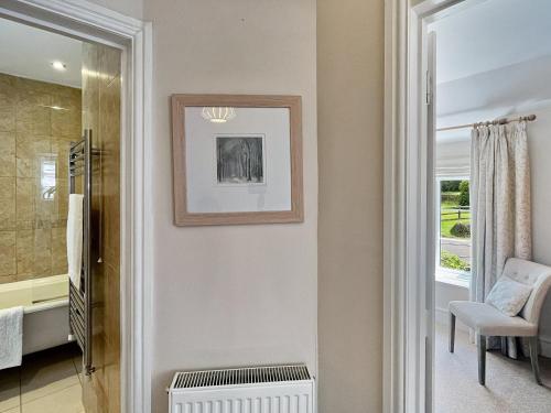 a living room with a chair and a window at Magnolia Cottage in Porlock