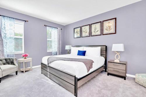 a bedroom with purple walls and a bed and a chair at Upstay Luxury Resort Home w Private Pool & Hot Tub in Kissimmee