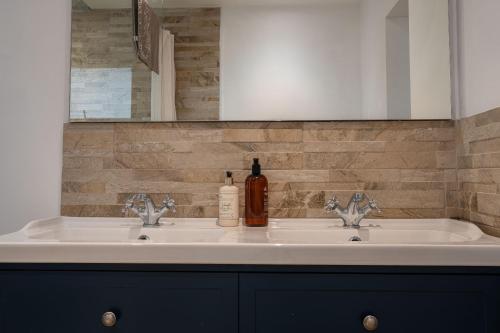 a bathroom with two sinks and a bottle of alcohol at montrose lodge in Cheltenham