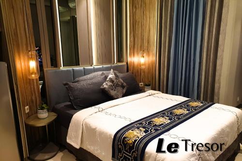 a small bedroom with a bed with a mirror at Le Tresor Benson Apartment at Supermal Pakuwon in Surabaya