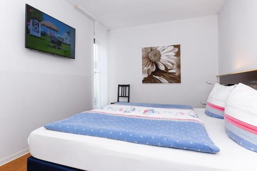 a bed in a bedroom with two pictures on the wall at Ferienwohnungen MARENOR in Bensersiel