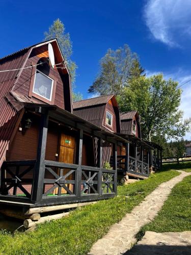 a large wooden house with a roof at Khatky Na Penkakh in Vorokhta