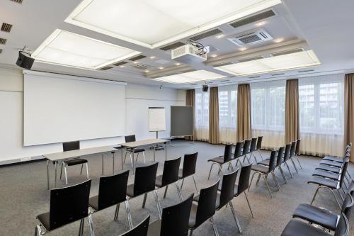 a conference room with chairs and a whiteboard at Austria Trend Hotel Europa Graz Hauptbahnhof in Graz