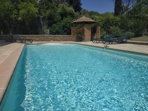 une piscine avec deux chaises et un gazebo dans l'établissement Haut de Villa VERDUREVE location de vacances, à Fréjus
