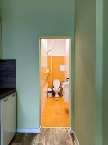 a bathroom with a toilet and a door to a room at Студио Top City Center in Plovdiv