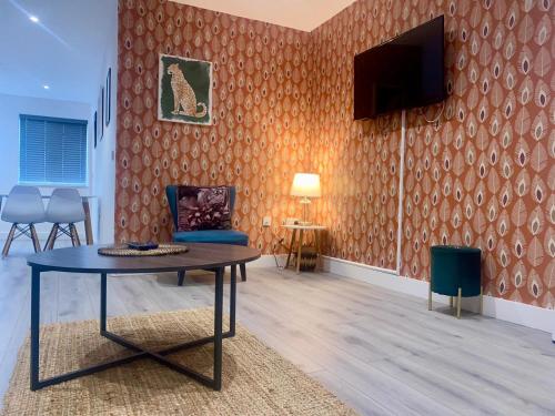 a living room with a table and a tv on a wall at Apartment 2 in Manchester
