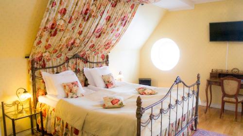 a bedroom with a bed with a floral curtain at Färna Herrgård & Spa in Färna
