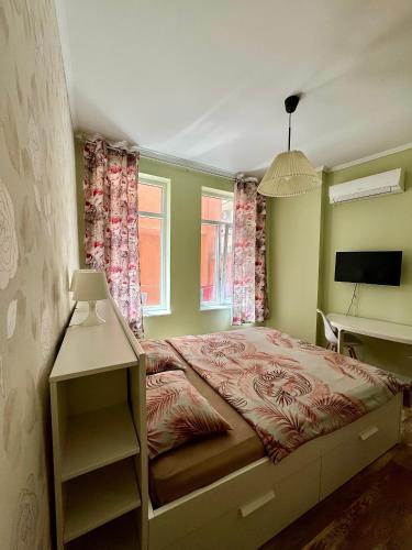 a bedroom with a bed and a desk in it at Студио Top City Center in Plovdiv
