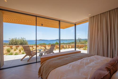 une chambre avec un lit et une vue sur l'océan dans l'établissement Villa Lucia Arinella, à Pinarellu