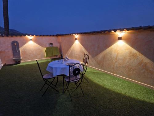 a table and two chairs in a courtyard at night at Casa Susanna Rural Sardinia in Sini