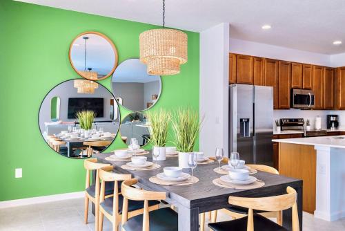 a kitchen and dining room with a table and mirrors at 8BR Resort Home with Games Room and BBQ in Kissimmee