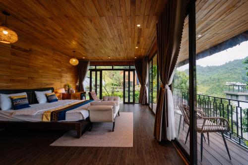 a bedroom with a bed and a balcony at Lotus Premium Lodge - Lotus Group Tours in Ha Giang