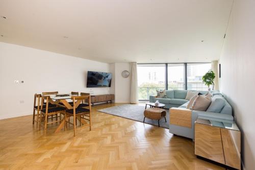 a living room with a couch and a table at Spacious, Modern 3-Bed Home in London