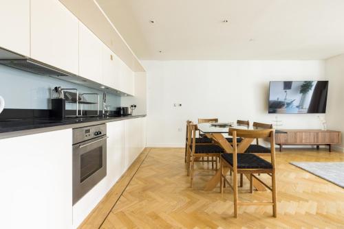 a kitchen and dining room with a table and chairs at Spacious, Modern 3-Bed Home in London