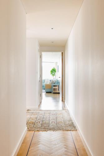 a hallway with white walls and a rug at Spacious, Modern 3-Bed Home in London