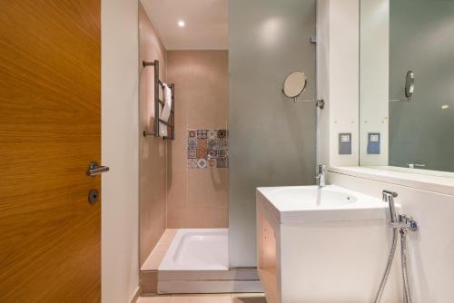 a bathroom with a sink and a bath tub at Spacious, Modern 3-Bed Home in London