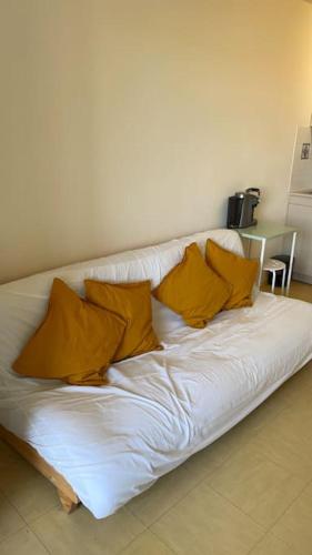 - un canapé blanc avec des oreillers jaunes dans l'établissement Joli studio à Marseille 14-ème, à Marseille