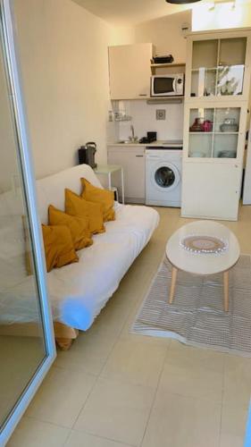 un salon avec un canapé blanc et une table dans l'établissement Joli studio à Marseille 14-ème, à Marseille