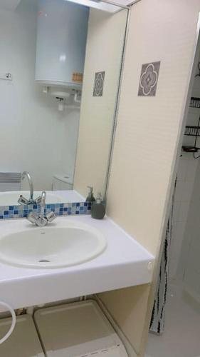 une salle de bain blanche avec un lavabo et un miroir dans l'établissement Joli studio à Marseille 14-ème, à Marseille