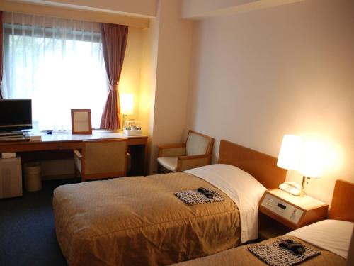 Hotel New Star Ikebukuro في طوكيو: غرفة فندقية بسريرين ومكتب