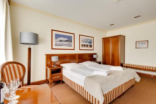 a hotel room with a bed and a table at Villa Meduza in Kołobrzeg