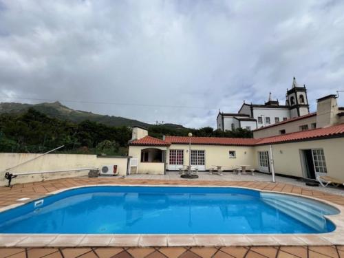 a large swimming pool in front of a building at Casa da Fazenda in Santa Cruz das Flores