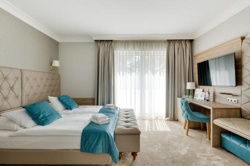 a hotel room with a bed and a desk at Villa Meduza in Kołobrzeg