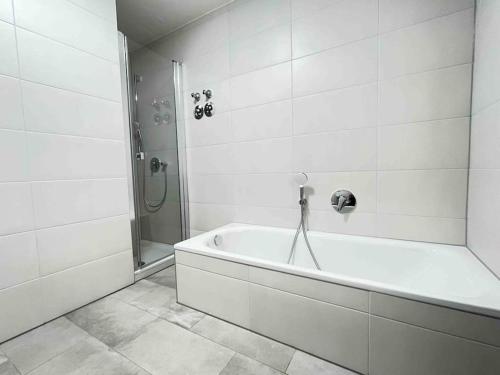 a white bathroom with a tub and a shower at LAP101 - Große Moderne Monteurwohnung Übergangswohnung in Lappersdorf