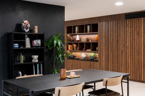 a dining room with a black table and chairs at Cove Landmark Pinnacle in London