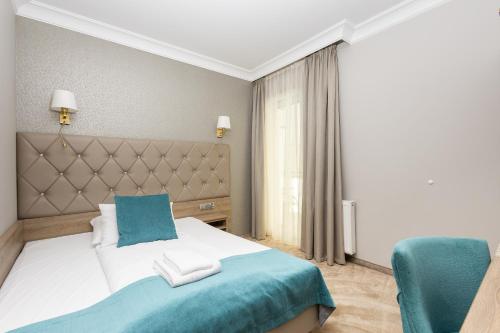 a bedroom with a bed and a blue chair at Villa Meduza in Kołobrzeg
