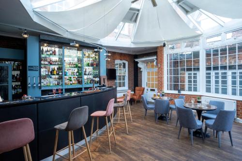 a bar in a restaurant with tables and chairs at Warbrook House Heritage Hotel in Hook