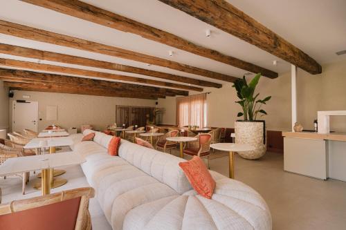 a large room with white couches and tables at Hotel De Baian in Jabbeke
