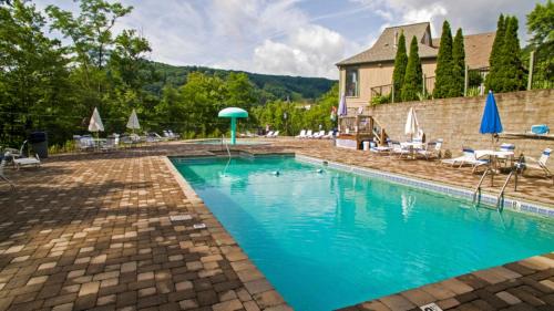 Una piscina con sillas y sombrillas al lado de un edificio. en Mtn Chalet Wpool-hot Tub-gym-game Room-sauna, en Gatlinburg