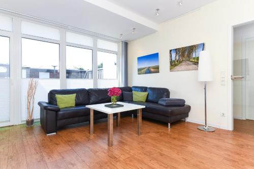 a living room with a couch and a table at Ferienwohnungen MARENOR in Bensersiel