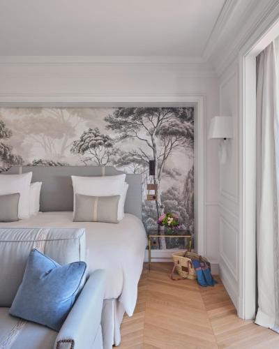 a white bedroom with a large bed and a couch at Airelles Château de la Messardière in Saint-Tropez