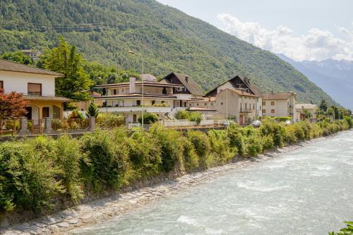 a row of houses next to a river at Casa dei Pini in Tirano