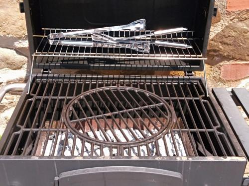 a grill with tongs and tongs on it at Podere Biricocolo - Il Cortile in Bucine