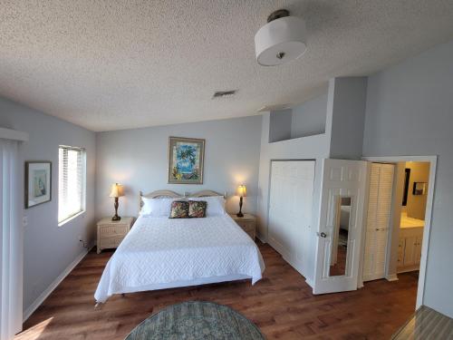 a bedroom with a large white bed and wooden floors at Waterfront Getaway in Hudson