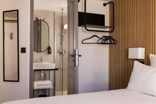 a bedroom with a bed and a sink and a mirror at Korner Opera in Paris
