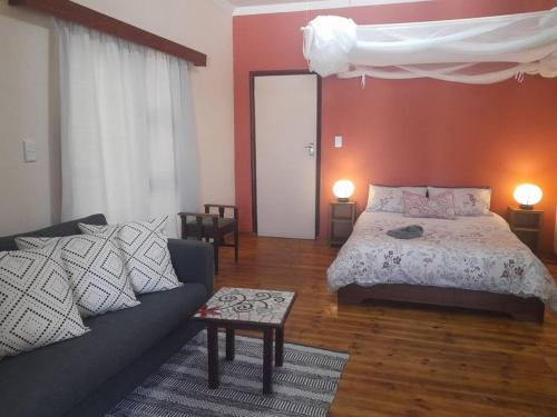 a living room with a bed and a couch at Peaceful Oasis near City Centre in Windhoek