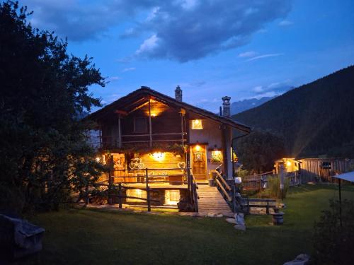 a house with lights on the outside at night at CleMaison Antica Dimora Apartments CIR VDA GIGNOD 0013 in Gignod