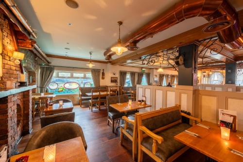 a restaurant with wooden tables and chairs and a bar at The Harbour Inn in Buncrana