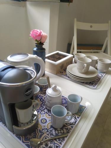 a counter top with cups and tea sets on it at Piccolo borgo antico Cefalù in Cefalù