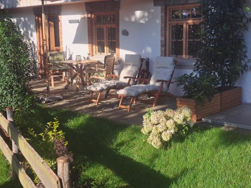 a patio with chairs and a table in front of a house at Exklusives STALL-LOFT "ZUM PULVERER" - Naturdesign hinter historischen Mauern - AusZeit für 2 inmitten des Isarwinkels in Gaißach