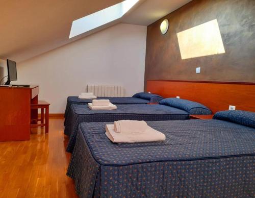 a room with two beds with towels on them at Hotel Villa De Lerma in Lerma