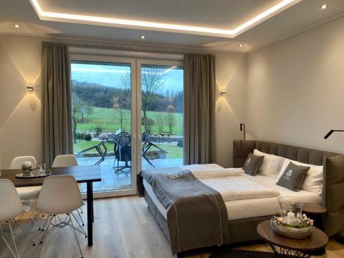 a bedroom with a bed and a table and a patio at DRIEHOF LifeStyle Classic Apt 5 in Tecklenburg